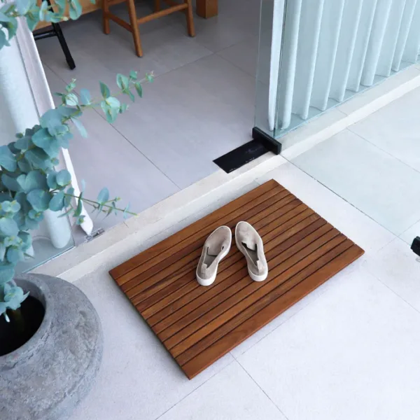 58x80 cm boyutlarında, teak ağacından üretilmiş kaydırmaz ahşap paspas, balkon, teras ve daire girişleri için ideal doğal ve şık bir zemin çözümü.
